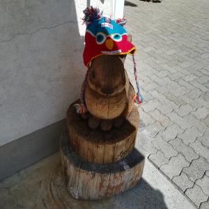 Ekta, a red and blue knitted hat, atop a wooden rabbit in  Switzerland.